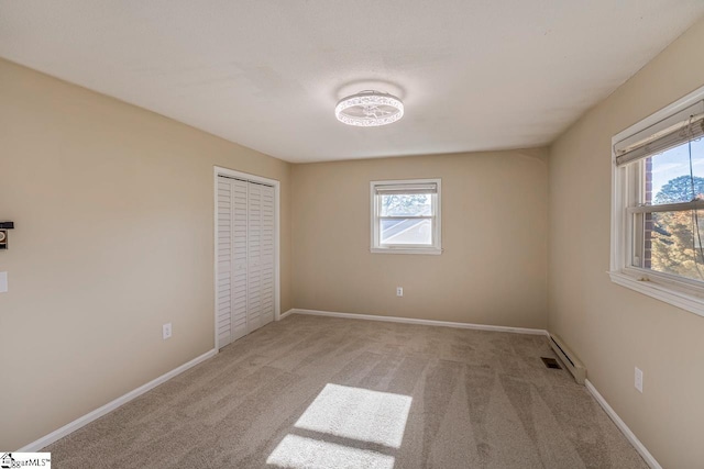 unfurnished bedroom with light colored carpet, a closet, and multiple windows