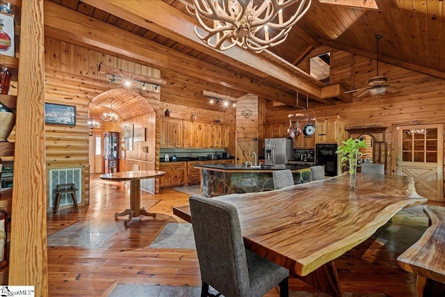 dining space featuring high vaulted ceiling, beamed ceiling, log walls, wood ceiling, and light wood-type flooring