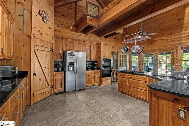 kitchen with sink, beam ceiling, wooden walls, black appliances, and wooden ceiling