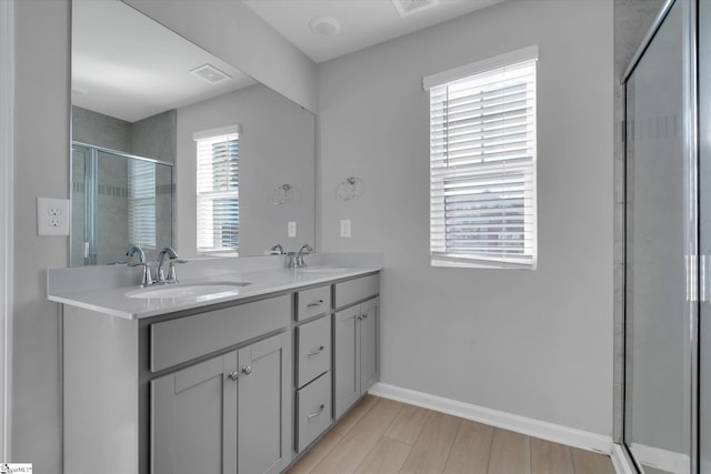 bathroom with vanity, an enclosed shower, and wood-type flooring