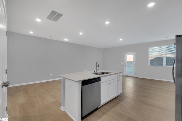 kitchen featuring sink, white cabinetry, a center island with sink, light wood-type flooring, and stainless steel appliances