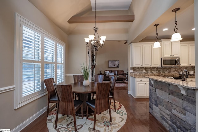 dining area with plenty of natural light, dark hardwood / wood-style floors, and a notable chandelier