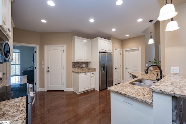 kitchen with appliances with stainless steel finishes, decorative light fixtures, sink, and white cabinets