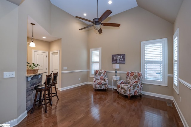 living area with high vaulted ceiling, dark wood-type flooring, and ceiling fan