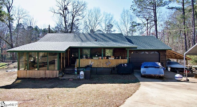 view of front facade with a porch, a garage, and a sunroom