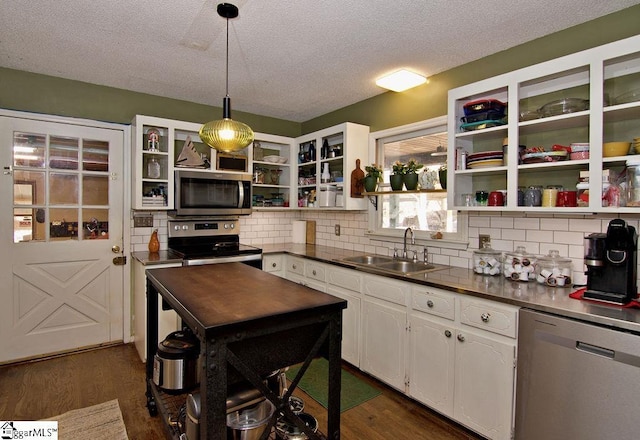 kitchen featuring sink, white cabinets, dark hardwood / wood-style flooring, hanging light fixtures, and stainless steel appliances