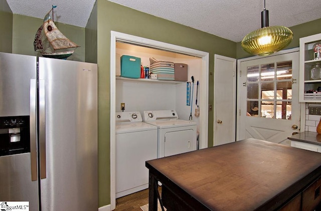 interior space with stainless steel fridge, separate washer and dryer, a textured ceiling, and decorative light fixtures