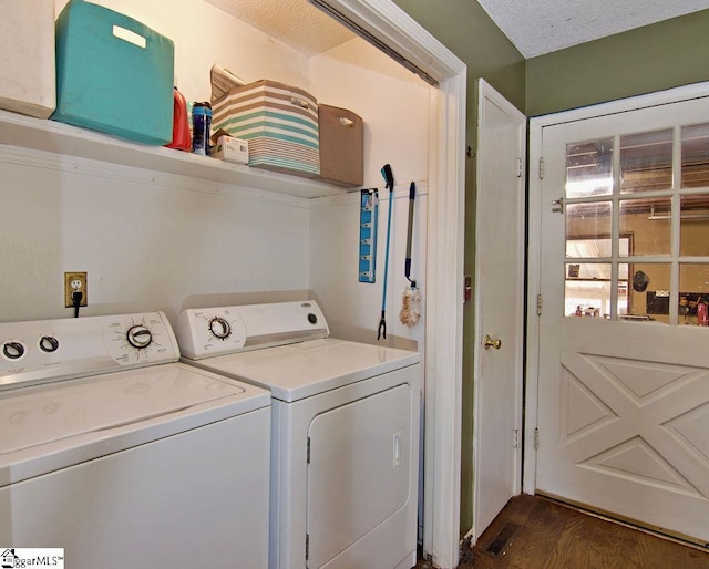 clothes washing area with dark wood-type flooring, washer and clothes dryer, and a textured ceiling