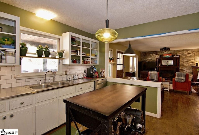 kitchen featuring sink, hanging light fixtures, dark hardwood / wood-style floors, a textured ceiling, and white cabinets