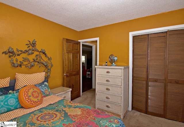 carpeted bedroom with a textured ceiling and a closet