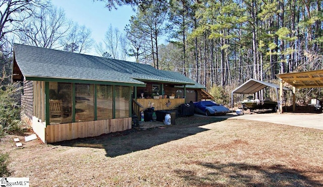 view of side of property featuring a carport and a sunroom