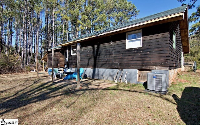 view of side of property featuring a yard and central AC unit