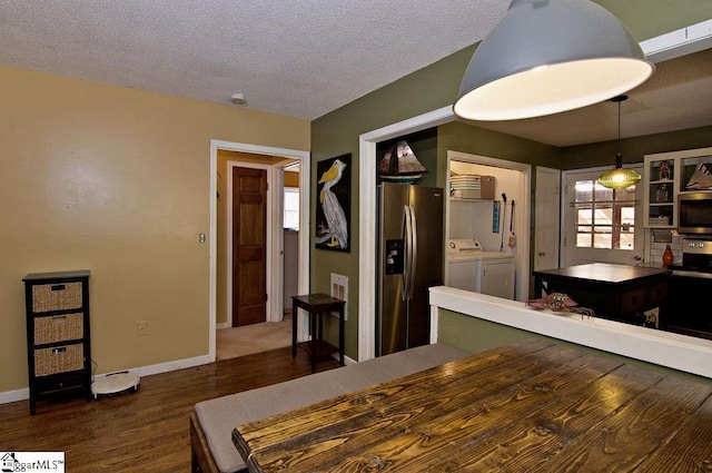 dining room featuring dark hardwood / wood-style floors, washer and clothes dryer, and a textured ceiling