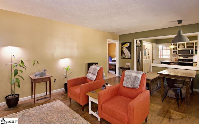 living area with dark hardwood / wood-style flooring and a textured ceiling