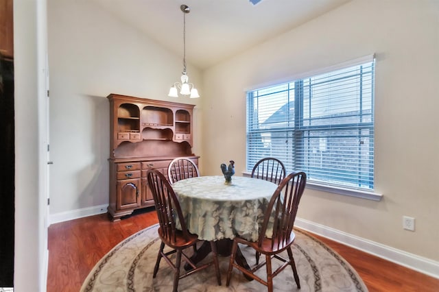 dining room with vaulted ceiling, dark wood-type flooring, and a chandelier