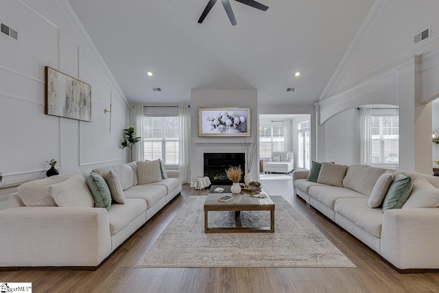 living room with dark hardwood / wood-style flooring, crown molding, high vaulted ceiling, and ceiling fan