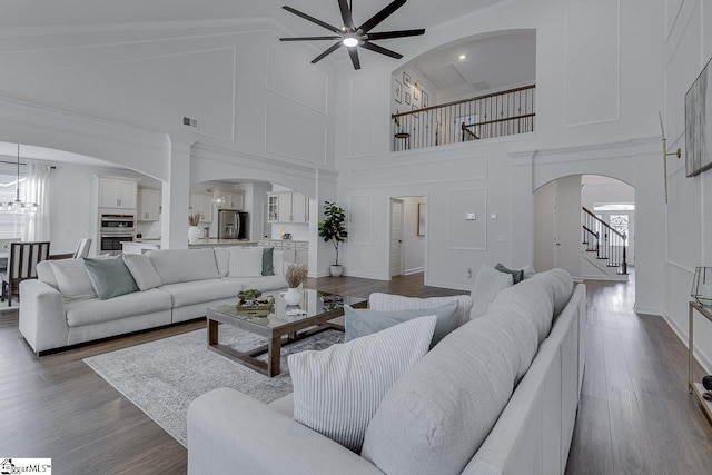 living room featuring hardwood / wood-style flooring, lofted ceiling, and ceiling fan with notable chandelier