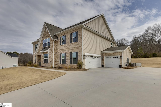 view of front of property featuring a garage, central AC, and a front lawn