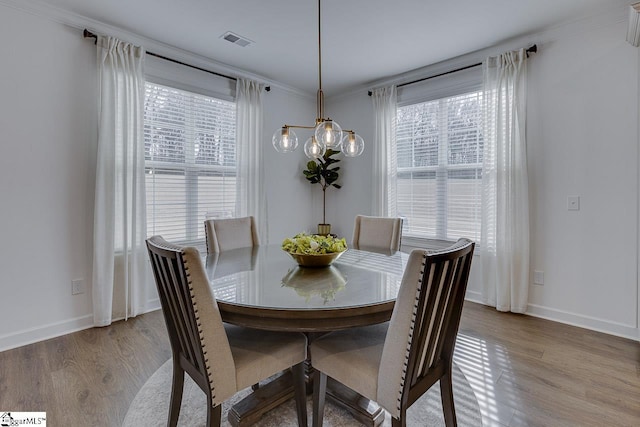 dining room featuring ornamental molding, a wealth of natural light, and light hardwood / wood-style floors