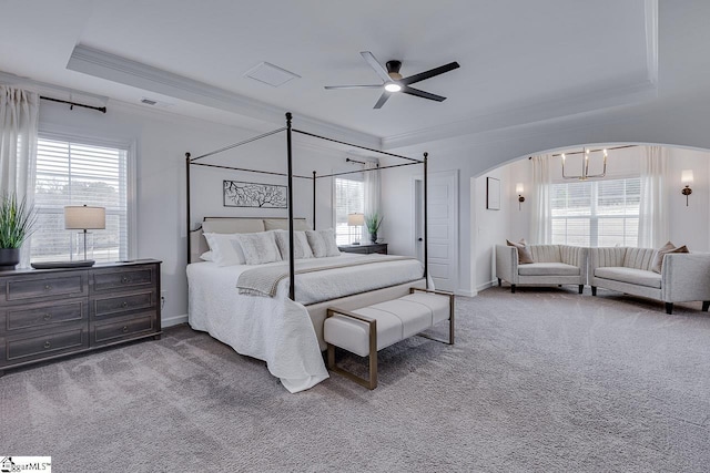 bedroom featuring multiple windows, ornamental molding, carpet, and a tray ceiling