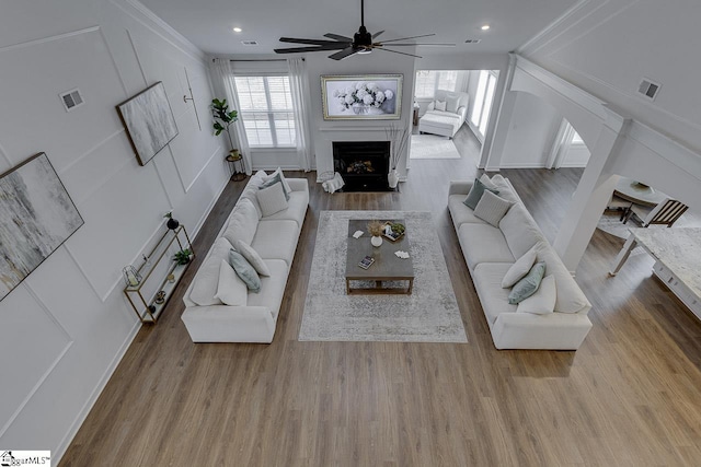 living room with ceiling fan, vaulted ceiling, and light hardwood / wood-style flooring