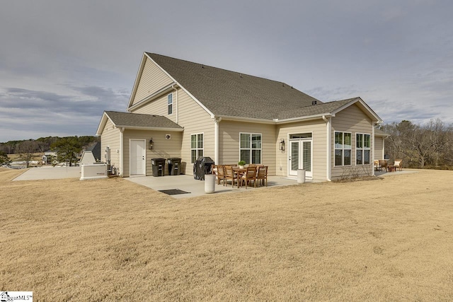 back of property with a lawn and a patio