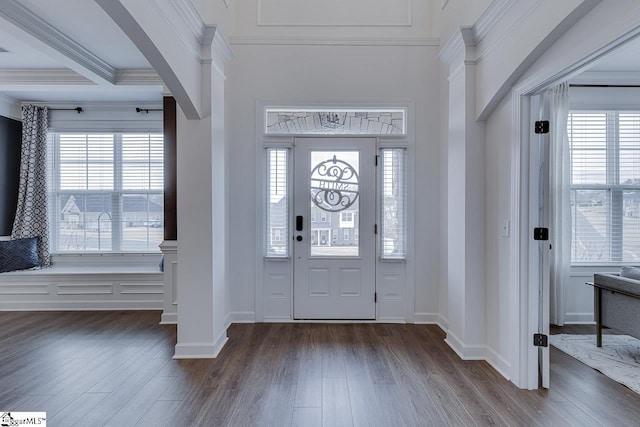 entrance foyer featuring ornamental molding, plenty of natural light, and dark hardwood / wood-style floors