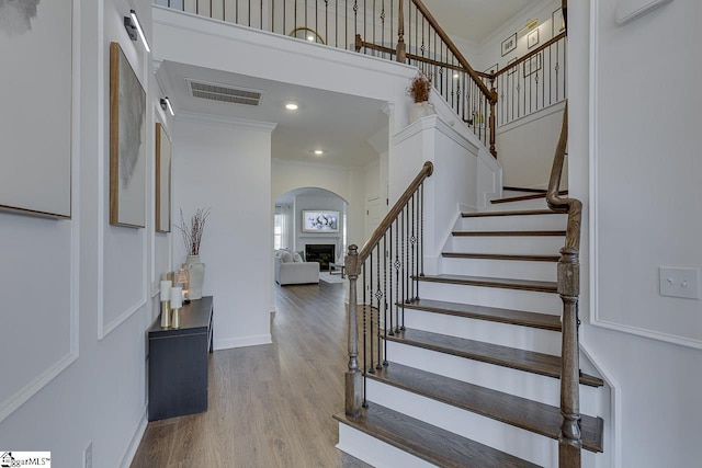 foyer with ornamental molding, hardwood / wood-style floors, and a high ceiling