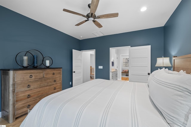 bedroom featuring ceiling fan, connected bathroom, and light hardwood / wood-style floors