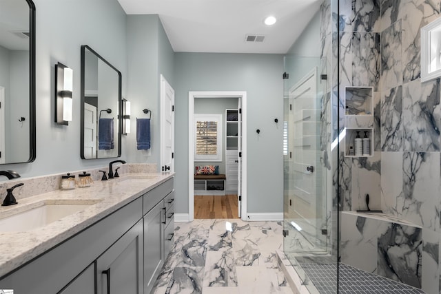 bathroom with vanity and a shower with door