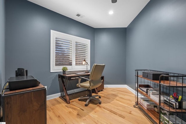 home office with light hardwood / wood-style flooring