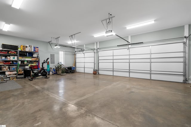 garage with a garage door opener and electric panel