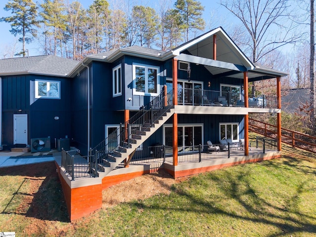 rear view of property featuring central air condition unit and a lawn