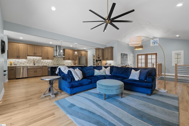 living room with french doors, lofted ceiling, and light hardwood / wood-style floors