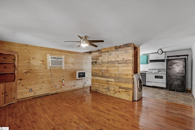 interior space with heating unit, washer / clothes dryer, wood-type flooring, a wall mounted AC, and ceiling fan