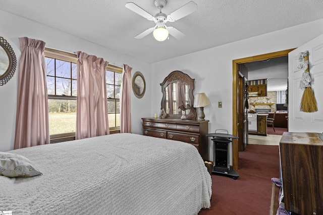 carpeted bedroom featuring ceiling fan and a textured ceiling