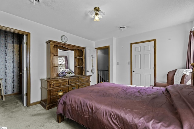 bedroom featuring light carpet and a textured ceiling