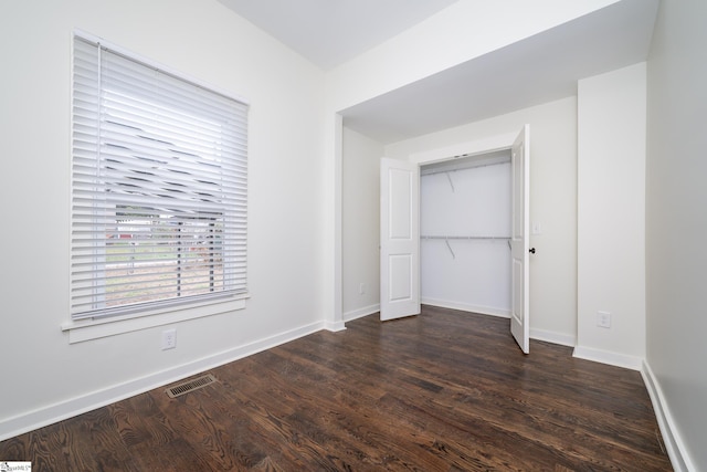 unfurnished bedroom featuring dark hardwood / wood-style flooring and a closet