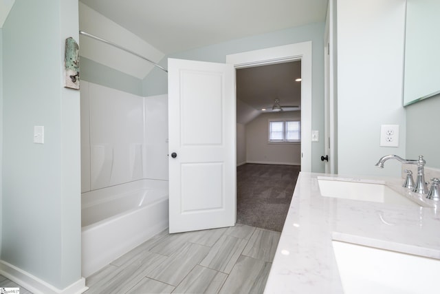 bathroom featuring lofted ceiling, vanity, and washtub / shower combination