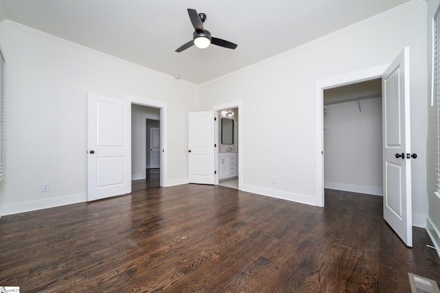 unfurnished bedroom with crown molding, connected bathroom, dark hardwood / wood-style flooring, a spacious closet, and a closet