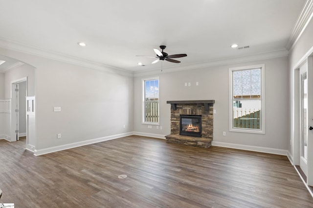 unfurnished living room featuring dark wood-type flooring, ornamental molding, and plenty of natural light