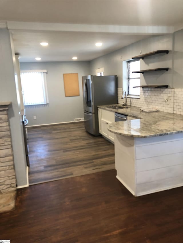 kitchen with sink, dark wood-type flooring, white cabinetry, light stone counters, and tasteful backsplash