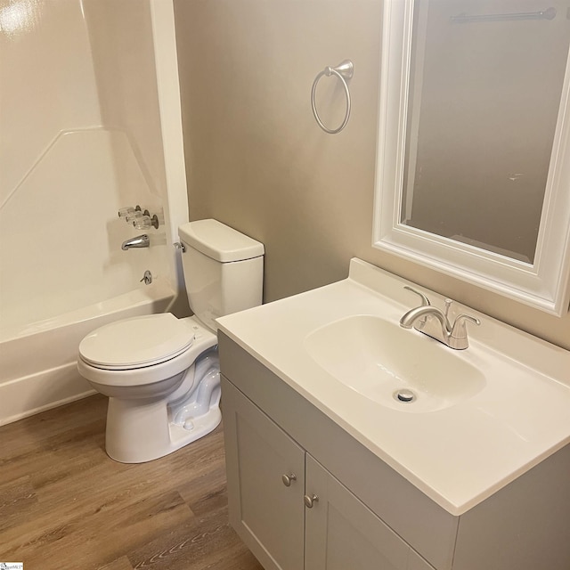 full bathroom with vanity, hardwood / wood-style floors, bathtub / shower combination, and toilet