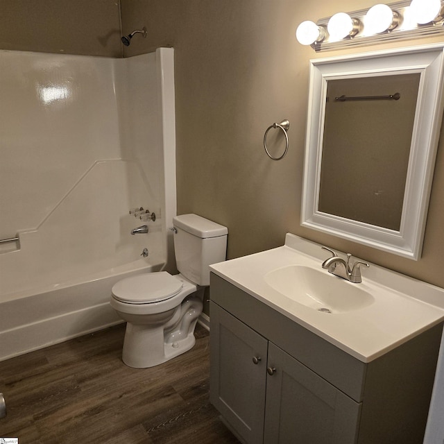 full bathroom with hardwood / wood-style flooring, bathing tub / shower combination, vanity, and toilet