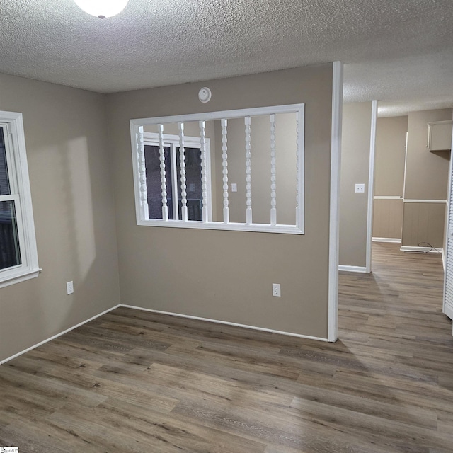 empty room with hardwood / wood-style floors and a textured ceiling