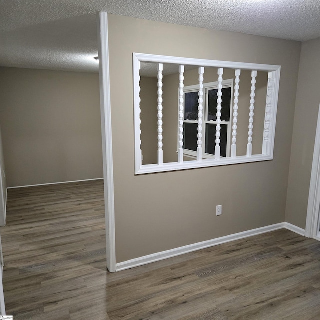 spare room featuring dark hardwood / wood-style floors and a textured ceiling