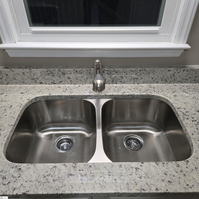 room details with light stone countertops and sink