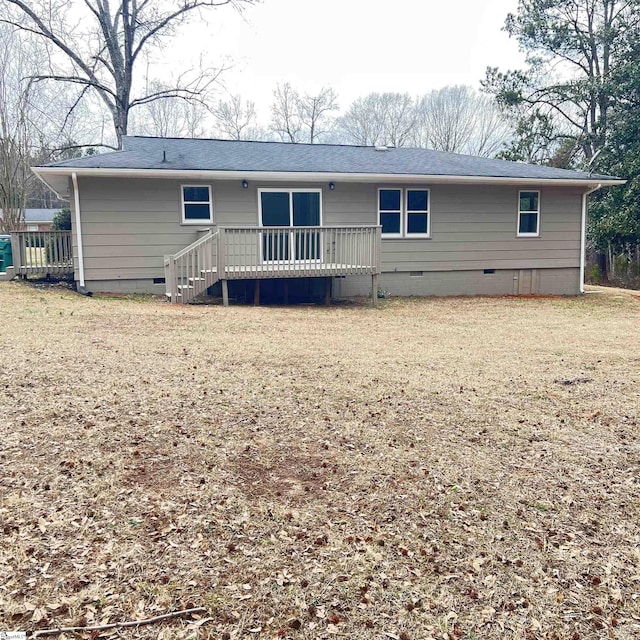 back of property with a yard and a deck