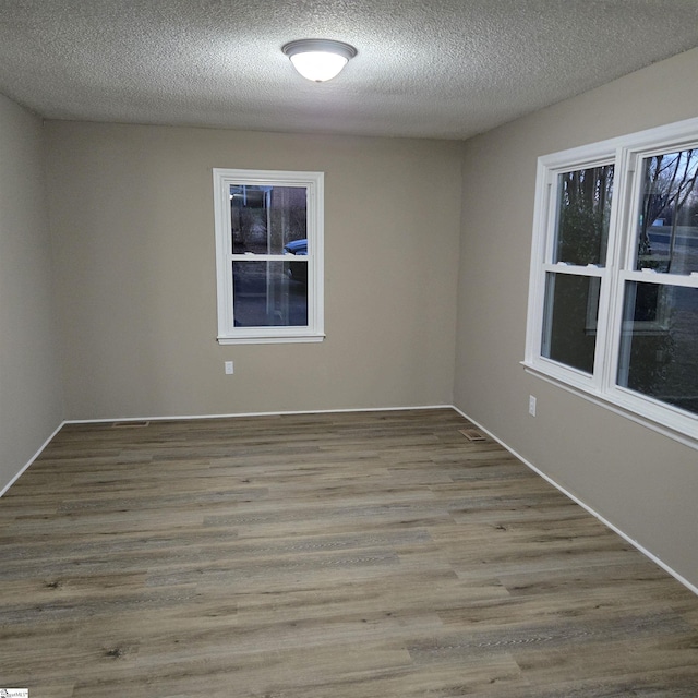 empty room featuring light hardwood / wood-style flooring and a textured ceiling