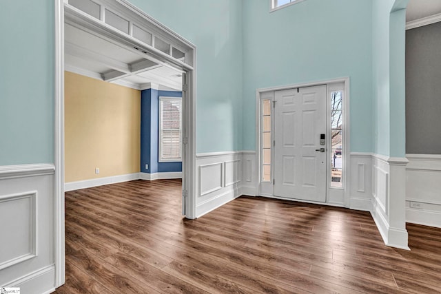 entrance foyer with coffered ceiling, dark wood-type flooring, a wealth of natural light, and beamed ceiling